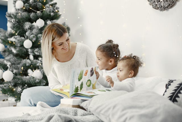mere-avec-deux-enfants-lisant-un-livre-sur-un-lit