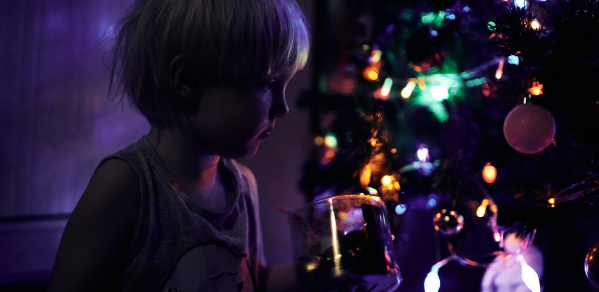 une-petite-fille-debout-devant-un-sapin-de-noel